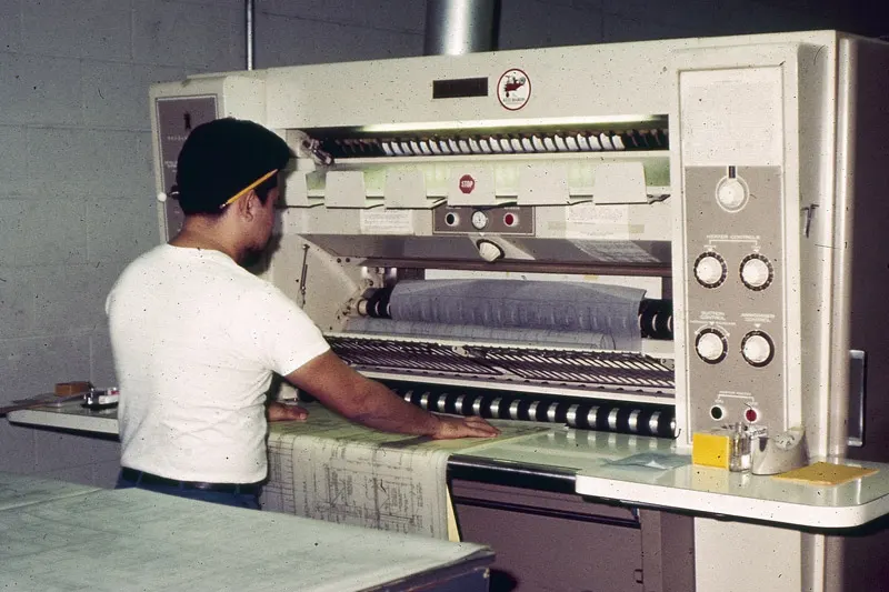 An old photo of a Thomas employee operating a diazo machine