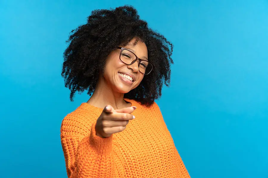 A woman smiling and pointing at you